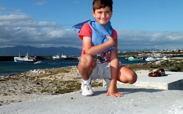 Johan-Stefan van Wyk sit hier op een van die vasmeerblokke (“mooring blocks") by die nuwe hawemuur in Gansbaai hawe